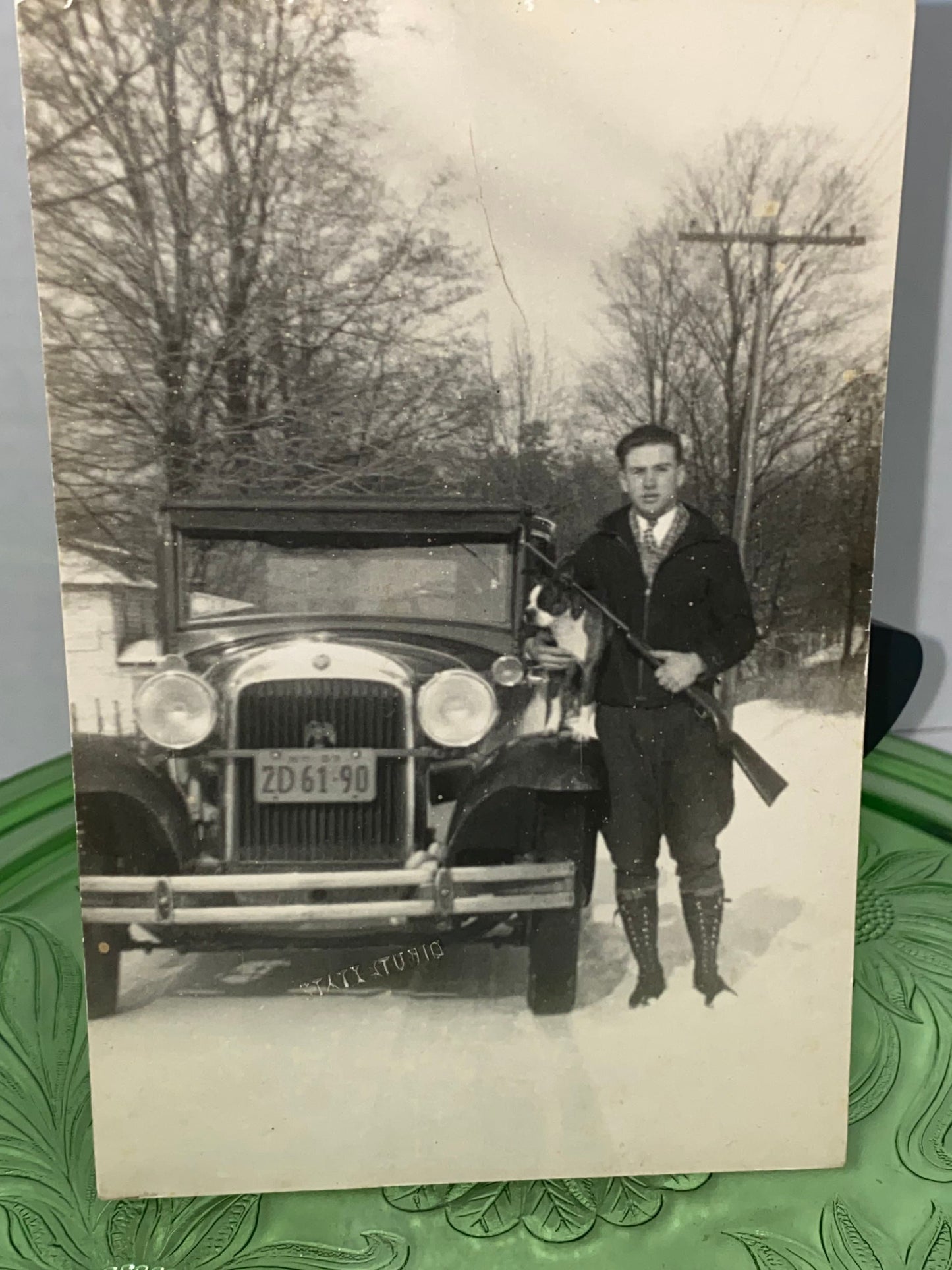 Antique photo young man in snow holding bill terrier & gun in front of car late teens roaring 20s